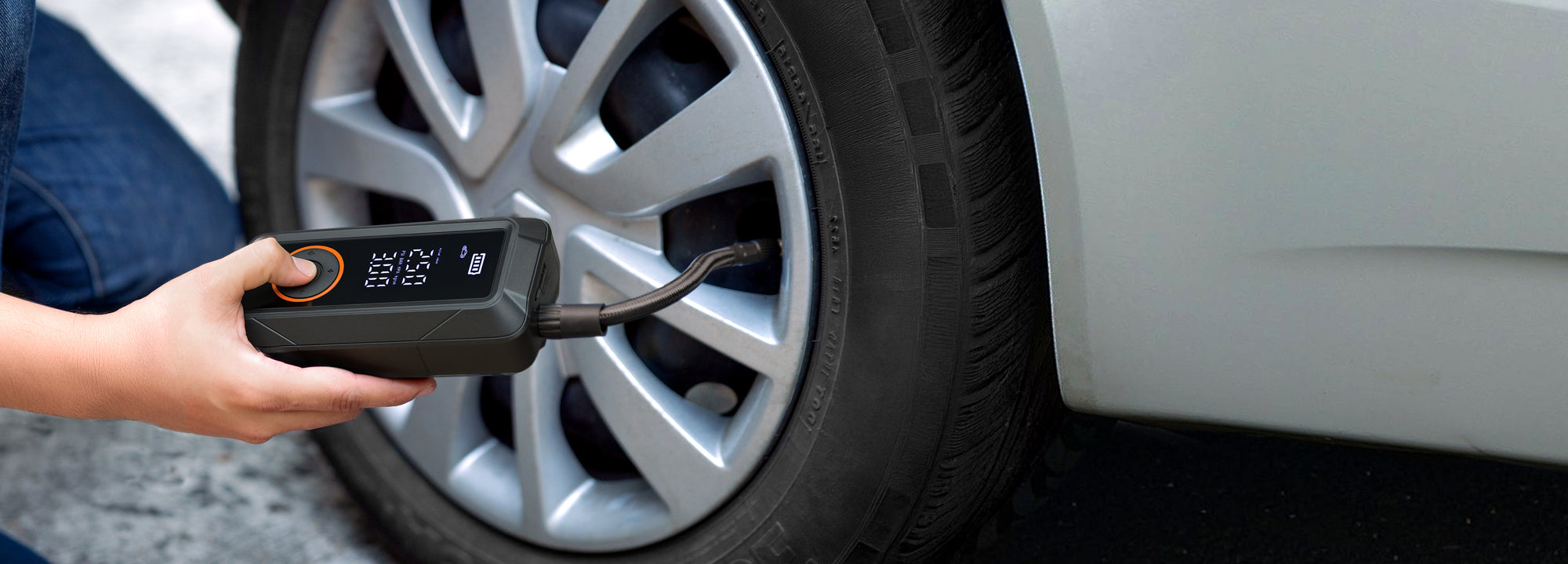 Persona usando el inflador de llantas portátil de la marca Inbogo en un automóvil