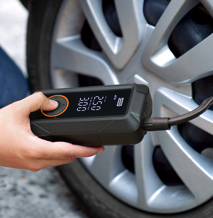 Persona usando el inflador de llantas portátil de la marca Inbogo en un automóvil