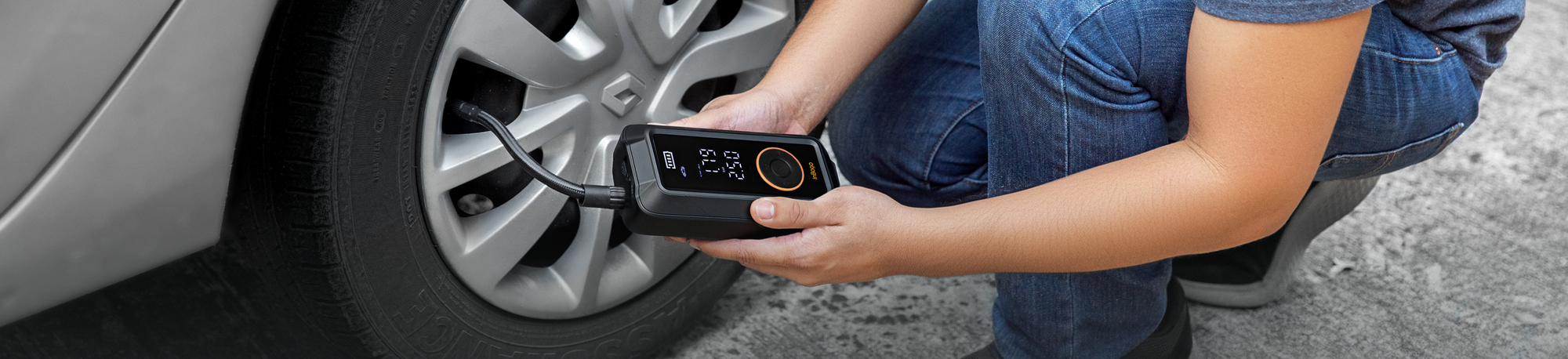 Persona usando un inflador portátil Inbogo para inflar llanta de automóvil.