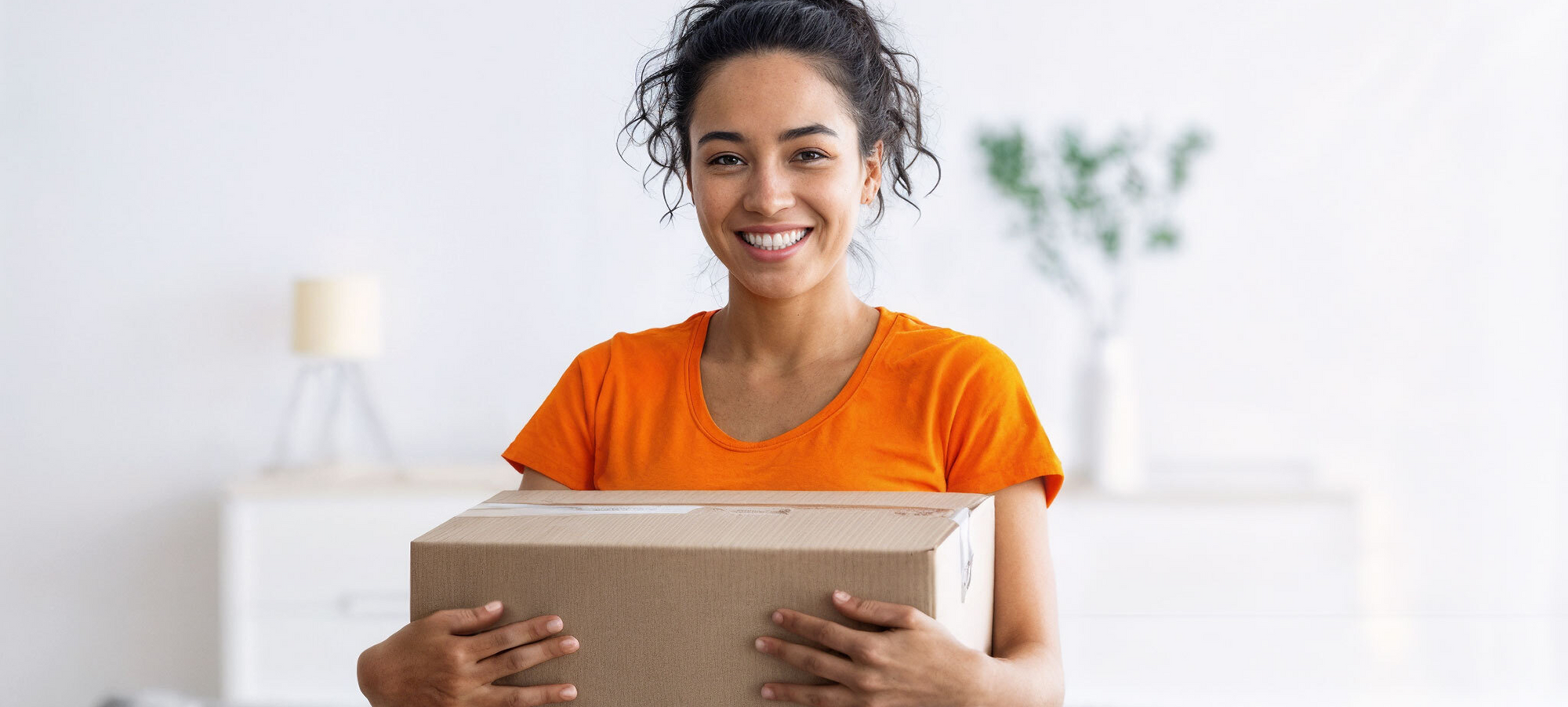 Mujer sonriendo mientras sostiene una caja, junto a los beneficios de compra en Inbogo.