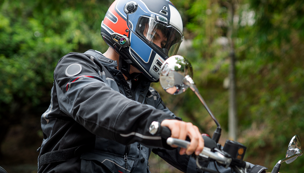 Motociclista usando el intercomunicador Bluetooth Inbogo en carretera
