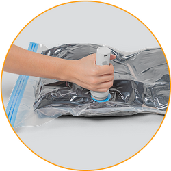Persona utilizando la bomba automática para extraer el aire de una bolsa al vacío Inbogo.